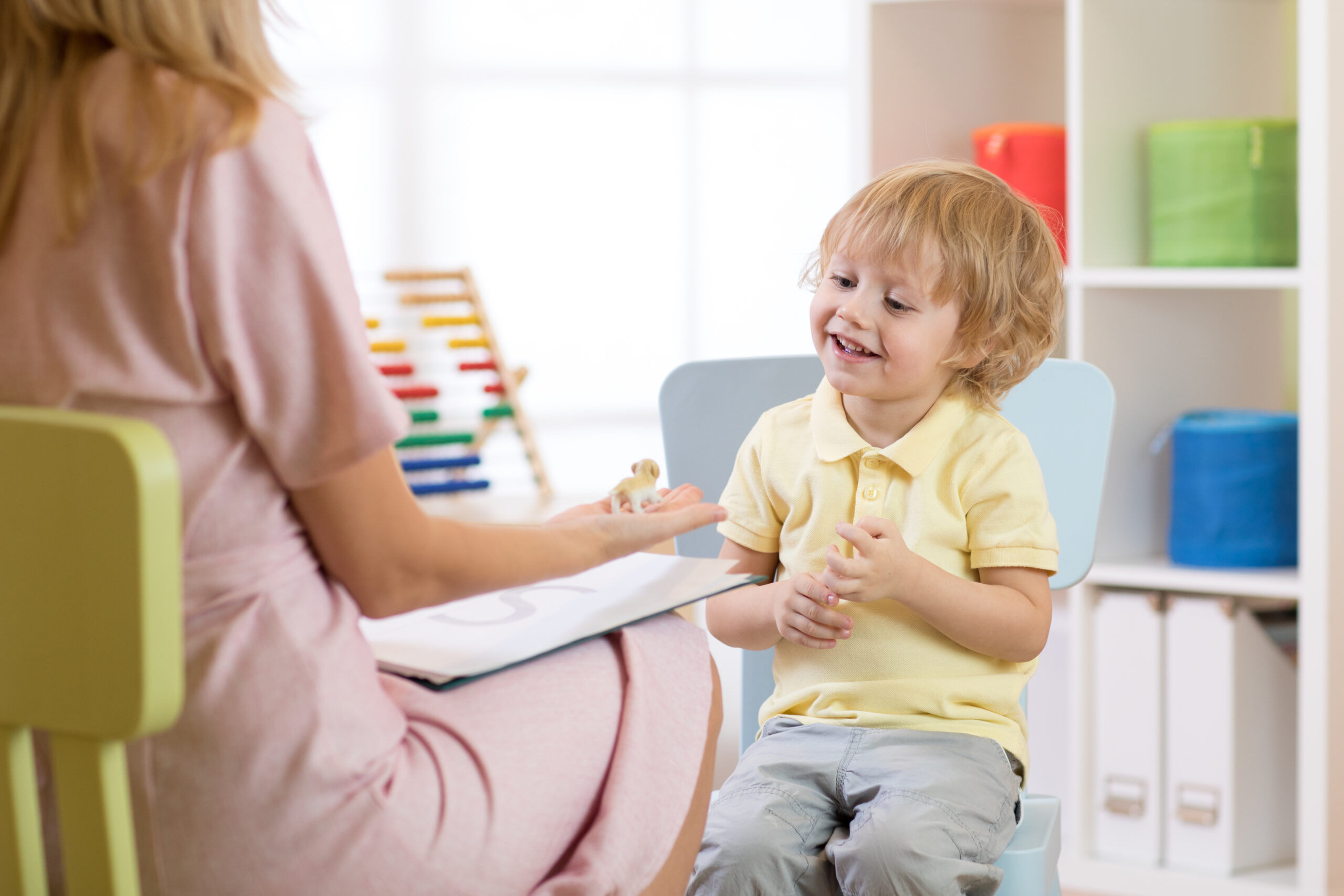 Child psychologist working with kid boy in office